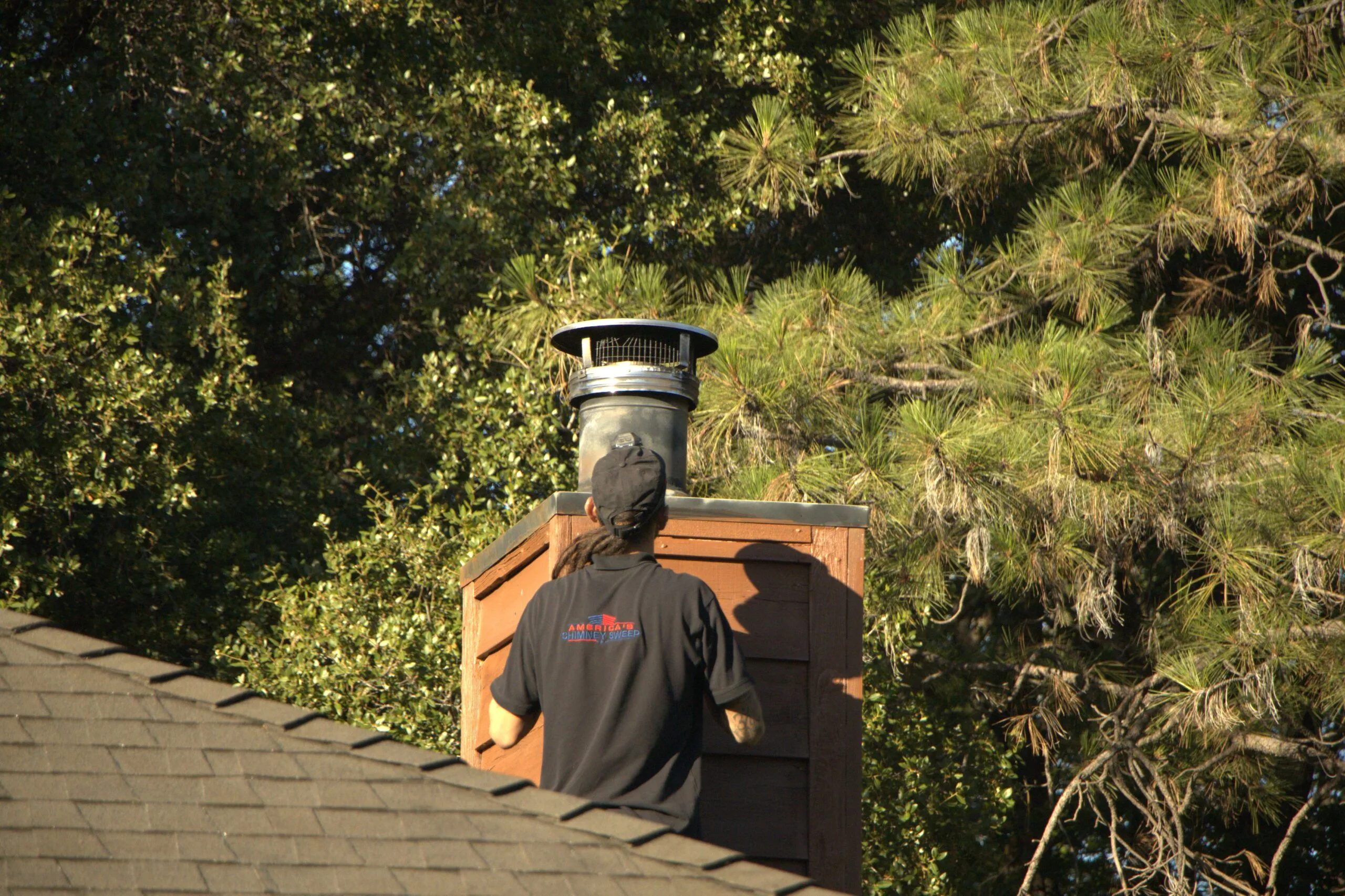 New stainless chimney cap installed on a masonry chimney